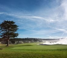 Wave crashing at the 18th hole at Pebble Beach