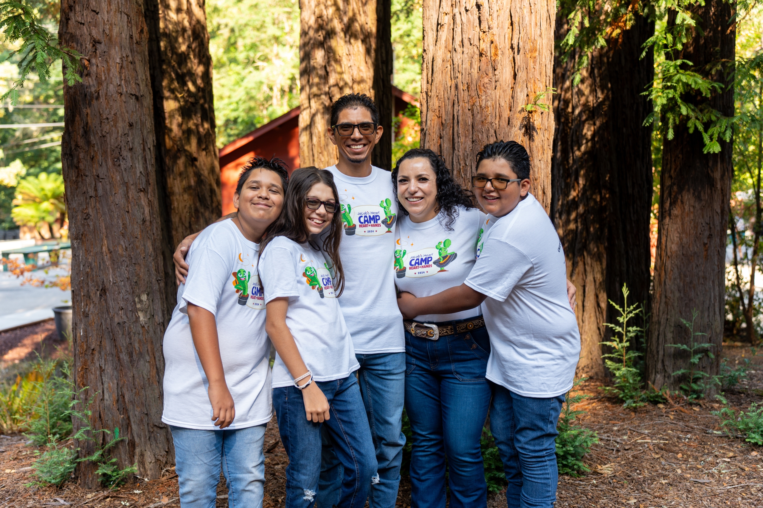 A smiling family of five wearing matching white 